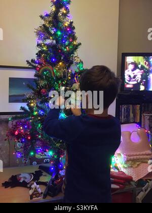 Boy decorating a Christmas Tree Banque D'Images