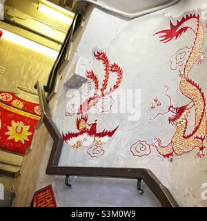 Des peintures murales sur les murs de l'entrée de l'escalier menant à un magasin de thé dans un Tong lau rénové, ou magasin, WAN Chai, île de Hong Kong Banque D'Images