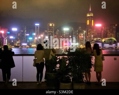 Les amateurs de shopping et les touristes apprécient le panorama de l'horizon de l'île de Hong Kong la nuit à partir du K11 ARTUS, un centre commercial de Tsim Sha Tsui, Kowloon Banque D'Images