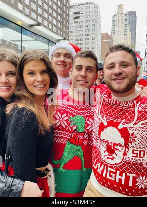 Un groupe de jeunes heureux vêtus de chandails de Noël et de tenues de Père Noël décembre 2021 New York City Banque D'Images