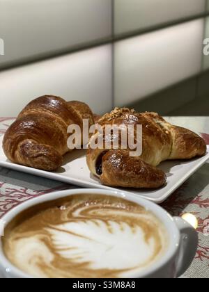 Petit-déjeuner italien typique avec un cappuccino et deux croissants au bar Banque D'Images