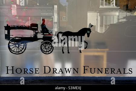 Une image d'un corbillard tiré par des chevaux sur la fenêtre d'un des locaux d'un sous-takers à Upton upon Severn Banque D'Images