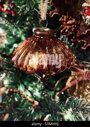 Décorations de Noël en bronze brun illuminées de lumières de fées sur un arbre de Noël Banque D'Images