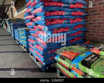 Sacs de compost empilés à l'extérieur d'un grand centre de jardin Banque D'Images