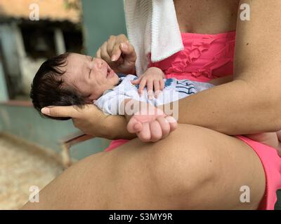 Nouveau-né garçon souriant dans les bras de sa mère.Perche bébé Covid -19.Taux de natalité, concept de maternité.La Havane, Cuba Banque D'Images