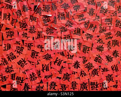 Bonne fortune, printemps, richesse et autres caractères chinois sur papier rouge Banque D'Images
