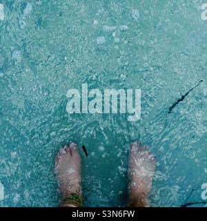 Les pieds d'une femme debout dans l'eau bleu clair du golfe du Mexique / océan / mer Banque D'Images