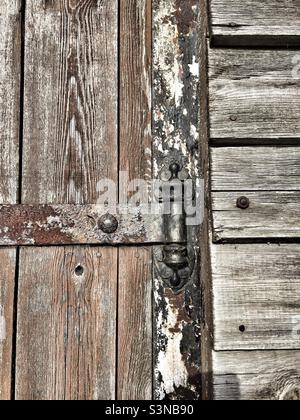 Détail d'une ancienne charnière de porte sur un vieux bâtiment en bois. Banque D'Images