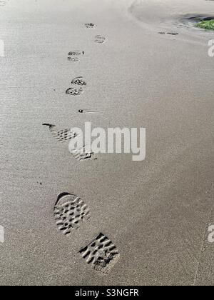 Empreintes de pas sur une plage de sable Banque D'Images