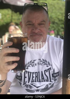 Homme avec un verre de coke Banque D'Images