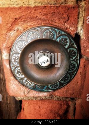 Ancienne cloche de porte en céramique avec encadrement en cuivre dans une maison majestueuse. Banque D'Images