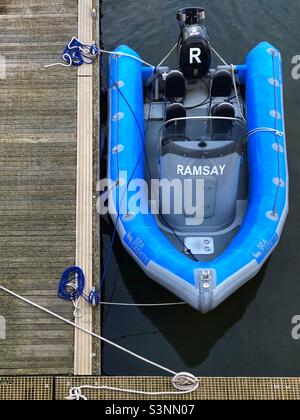 Bateau à moteur extérieur gonflable amarré dans le port Banque D'Images