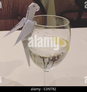 Origami oiseau sur un verre d'eau, Black Crab Restaurant, MSC Divina bateau de croisière Banque D'Images