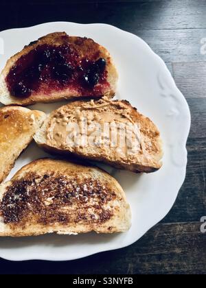 Un quadruple de toasts - confiture de cassis, beurre d'arachide, tartinade aux extraits de levure, marmelade d'orange, sur pain de tigre blanc grillé Banque D'Images