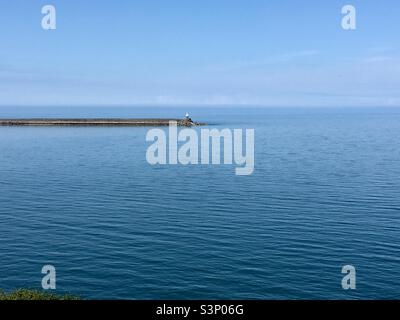 Phare sur une mer bleu profond et calme Banque D'Images