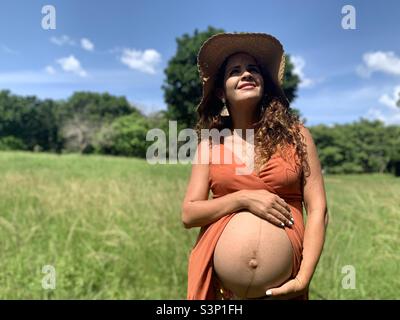 une femme enceinte de 8 mois caresse son ventre, ce qui montre la linea nigra. Attentes de grossesse. Banque D'Images