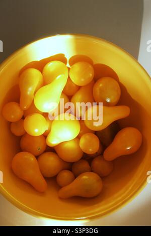 Tomates jaunes dans un bol jaune Banque D'Images