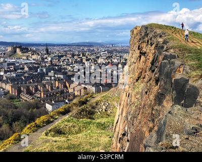 Personnes sur Salisbury Crags avec une vue sur le château d'Édimbourg et les toits de la ville, Holyrood Park, Edimbourg Ecosse Banque D'Images