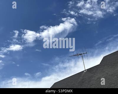 Ciel bleu clair au plafond et toit d'une maison dans l'Utah, aux États-Unis avec une antenne analogique de style ancien. Banque D'Images