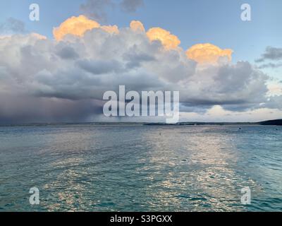 Les nuages semblent être sur le feu au-dessus de la mer au coucher du soleil Banque D'Images