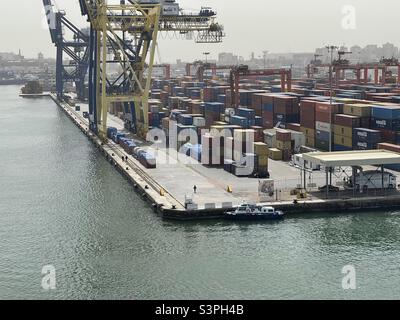 Terminal de conteneurs à Alexandrie, en Égypte, équipé de grues portiques et arrimé par des conteneurs de différents expéditeurs attendant le navire pour l'opération de cargaison pendant le temps ensoleillé du printemps. Banque D'Images