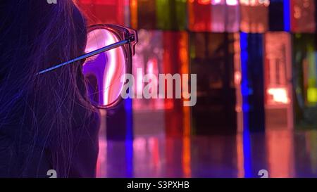Femme anonyme en très gros plan, regardant les fenêtres colorées recouvertes de gel à travers des lunettes Banque D'Images