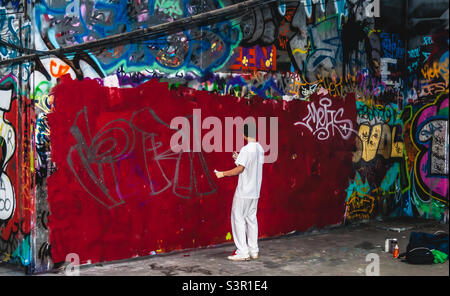 Un jeune artiste de rue vêtu de blanc commence à commencer une nouvelle pièce au parc de skate de Southbank à Londres, en 2009 Banque D'Images