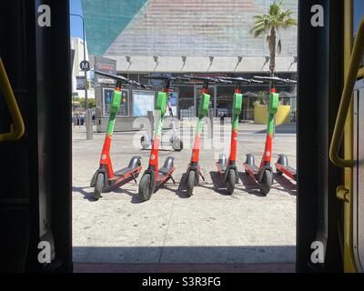 LOS ANGELES, CA, JUN 2021: Rangée de scooters électriques Lime colorés vus par les portes de bus à l'arrêt, Wilshire et Western Banque D'Images