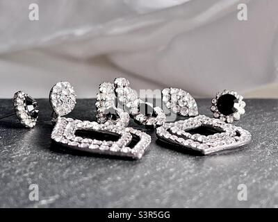 Bijoux de fantaisie art déco, boucles d'oreilles, strass clair et pierres précieuses noires, sur ardoise avec fond blanc Banque D'Images