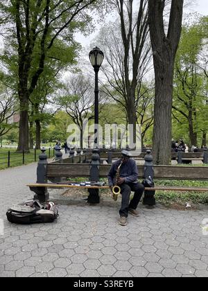 Un homme noir joue le saxophone à Central Park, New York. Banque D'Images