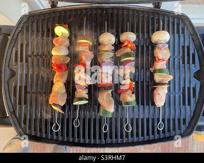 Kebabs de poulet et de légumes cuisant sur un barbecue à gaz Banque D'Images