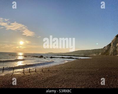 Le soleil descend le long de la plage Banque D'Images