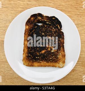 Burnt Toast sur une assiette blanche Banque D'Images