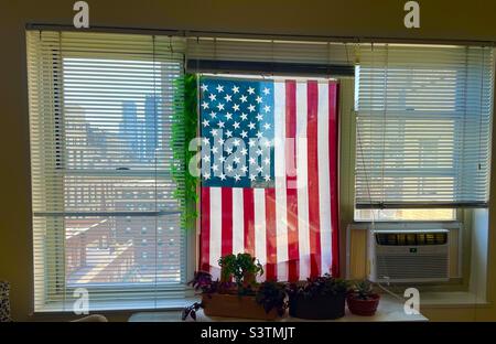 Drapeau américain suspendu dans la fenêtre d'un appartement de New York City Banque D'Images