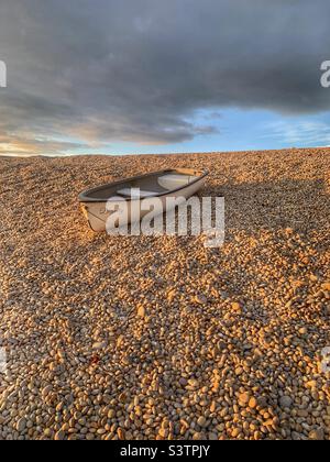 Petit bateau sur une banque de galets à la plage de Chesil Banque D'Images