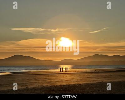 Les gens qui apprécient le coucher du soleil sur la plage de Harlech, Snowdonia, au nord du pays de Galles Banque D'Images