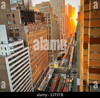 34th St. est aglow du coucher du soleil pendant Manhattatanhenge, été 2022, New York City, Etats-Unis Banque D'Images