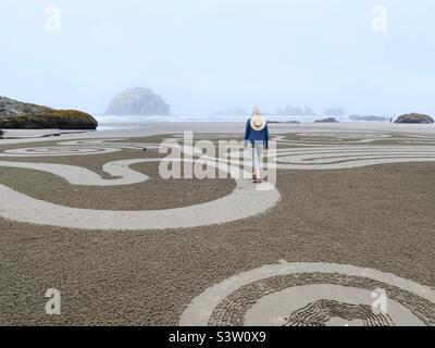 Une femme marchant dans un labyrinthe de sable sur face Rock Beach à Bandan, Oregon. Banque D'Images