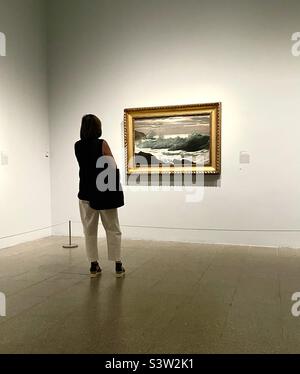 Femme regardant des œuvres d'art dans un musée Banque D'Images