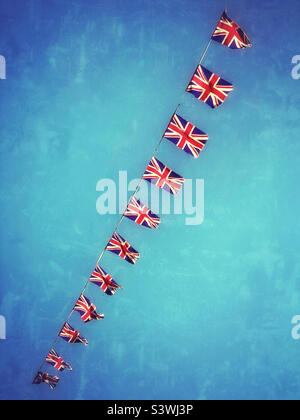 Image grunge et effet rétro d'une ligne de drapeaux Union Jack. Bunking, flottant dans le vent d'un été du Royaume-Uni, célébrant le Jubilé de platine de la Reine. Photo ©️ COLIN HOSKINS. Banque D'Images