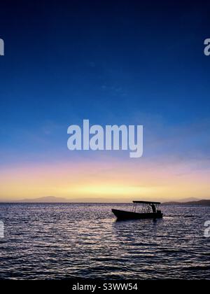 Un moteur de bateau de Panga près de la rive en début de matinée. Île de Tavarua, Fidji. Banque D'Images