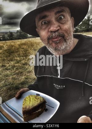 Homme mangeant le gâteau Banque D'Images