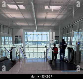 Terminaux de transit homme et garçon à l'aéroport international de Munich (Franz Josef Strauss) en Allemagne. Munich dispose d'installations très modernes et très complètes, avec un accent sur les soins aux passagers. Banque D'Images