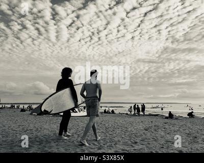 Les surfeurs marchent jusqu'à la mer dans le nord du Devon, en Angleterre, au Royaume-Uni Banque D'Images