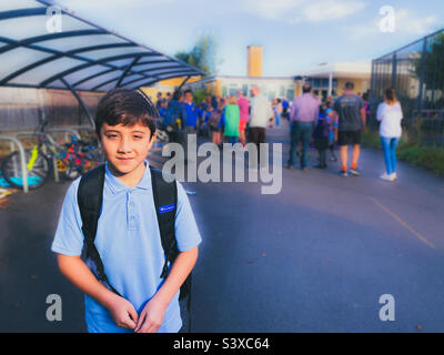 Un garçon qui revient à l'école pour le premier jour de la nouvelle année scolaire. Banque D'Images