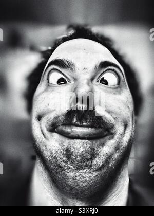 Homme au visage fou posant pour l'appareil photo Banque D'Images