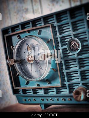 Radio-réveil vintage RCA couleur sarcelle sur une étagère en bois contre papier peint floral vintage Banque D'Images