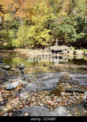 Plusieurs Inukshuks sur un lit de rivière dans un cadre d'automne coloré. Banque D'Images