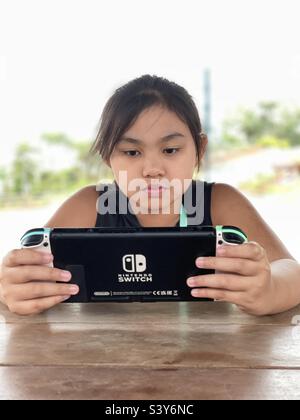 Enfant asiatique jouant avec nintendo Switch Animal Crossing Edition version 2 Banque D'Images