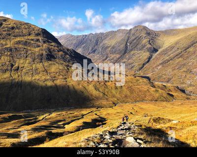 Marcheurs sur le chemin et les pentes de Munro Buachaville Etive Beag, avec vue sur la crête d'Aonach Eagach, Glencoe, Écosse Banque D'Images